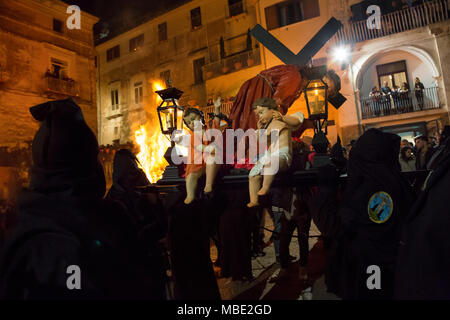 SESSA AURUNCA, Italia - 30 Marzo 2018 - La Easter Parade di cappucci neri camminando attraverso le strade di Sessa Aurunca, portando le statue dei Misteri della croce, Cristo morto e le tre Marie Foto Stock