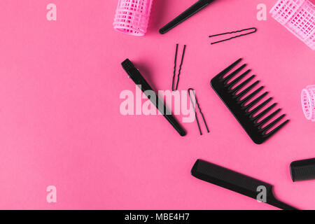 Lay piatto con bigodini e strumenti per parrucchieri, in rosa Foto Stock