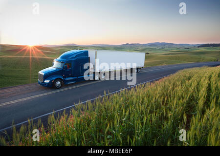 Commerciale di guida carrello se i campi di grano di Eastern Washington, Stati Uniti d'America al tramonto. Foto Stock