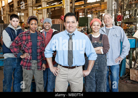 Un gruppo di 6 persone, lavoratori dipendenti presso una fabbrica di età mista e miscelati etnie, la diversità etnica, le donne e gli uomini. Foto Stock