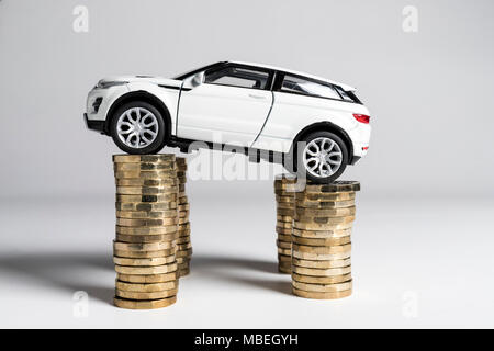 Un giocattolo Land Rover Evoque bilanciato su pali di £ 1 monete. Foto Stock