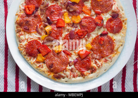 Pizza con salame e salsiccia per pizza e peperoni rossi e gialli Foto Stock