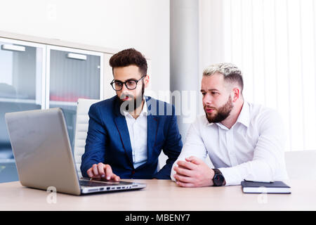Giovani colleghi di lavoro a lavorare su un nuovo progetto sul computer portatile Foto Stock