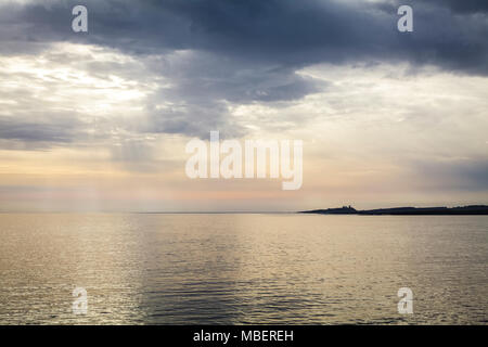Guardando attraverso il mare da Ebb il Cantuccio al castello di Dunstanburgh in Northumberland Foto Stock