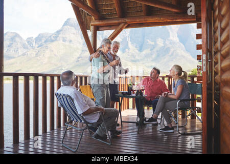 Attivo coppia senior amici di tostatura con bicchieri di vino sul lago balcone cabina Foto Stock