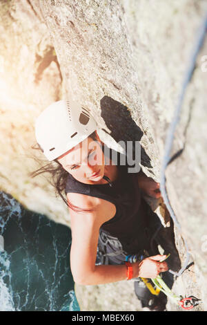 Determinato, femmina focalizzato scalatore di roccia di scala Foto Stock