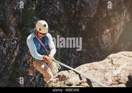 Maschio di rocciatore rappelling, discendente dalla fune Foto Stock