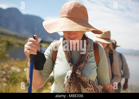 Attiva donna senior in sun hat escursionismo Foto Stock