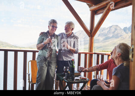 Felice active coppie senior bere vino sulla terrazza estiva Foto Stock