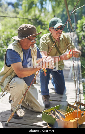 Attivo maschio senior amici preparando linee di pesca Foto Stock