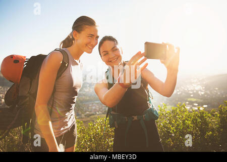 Femmina di arrampicatori tenendo selfie con la fotocamera del telefono Foto Stock