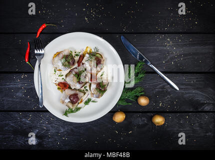 Spuntino russo da le aringhe salate, patate e cetrioli Foto Stock