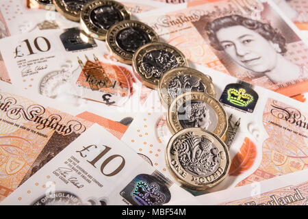 Nuovo stile di £ 1 monete sulla parte superiore del Regno Unito £ 10,00 note Foto Stock