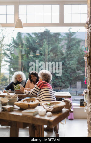 Le donne amici con smart phone al cafe vetrina Foto Stock