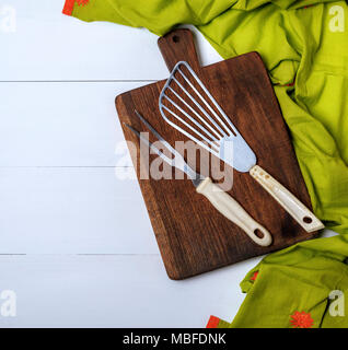 Cucina vintage forcella e scapola su un marrone la tavola di legno e verde su un tavolo bianco, spazio vuoto sulla sinistra Foto Stock