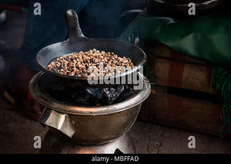 La tostatura i chicchi di caffè durante una cerimonia del caffè in Etiopia ad Addis Abeba Foto Stock