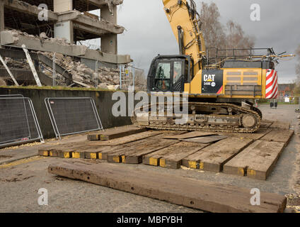 Escavatore idraulico cingolato da demolizione Cat 349 e ad alta portata a 360 gradi su rotopresse per legno, demolizione di calcestruzzo in cantiere a Bury uk Foto Stock