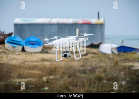 Drone battenti di fronte un sfondo sfocato di barche e di deposito Foto Stock