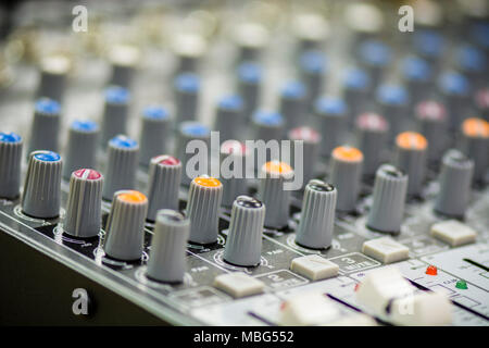 Close up di una console di mixaggio con cursori e pulsanti Foto Stock