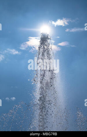 Fontana closeup: spruzzi di acqua contro il cielo nuvoloso in presenza di luce solare con una stanza per il tuo copytext Foto Stock