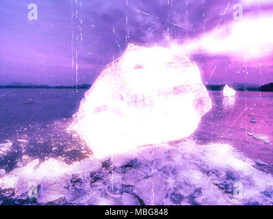 Effetto astratto. Vista in dettaglio in un ghiaccio con graffi profondi e crepe. Tagliare floe contro al cielo di sera e la luce spot. Foto Stock