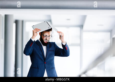 Imprenditore Desparated rompendo hes portatile con testa per problemi sul lavoro Foto Stock