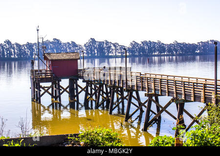 Pescatore solitario sul vecchio molo in legno sul fiume in Mattina presto Foto Stock