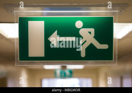 Uscita di emergenza / fire escape il segno di un tipo illuminato, per uso in spazi più scuri. Regno Unito (95) Foto Stock