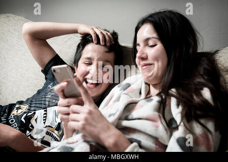 I bambini guardare divertenti video insieme su smart phone Foto Stock