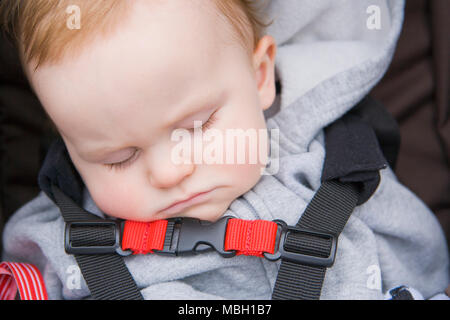 A dieci mesi di vecchio bambino addormentato nel suo passeggino. Foto Stock