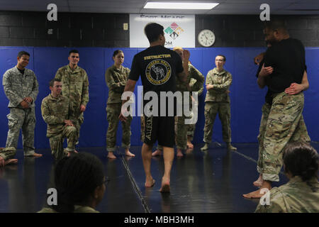 Stati Uniti Army Sgt. Nelson Rodriguez, assegnato alla 55Signal Company (lotta contro la telecamera) spiega il modificato cintura di sicurezza posizione durante il Basic Combatives corsi a Gaffney Centro Fitness situato a Fort George G Meade, Maryland, Dic 11, 2017. L'esercito combatives programma unità migliora la Combat Readiness mediante la costruzione di soldati' personale coraggio, fiducia e resilienza nonché la loro reattività situazionale al vicino quartiere minacce nell'ambiente operativo. Foto Stock