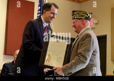 Gov. Scott Walker presenta un annuncio ai veterani delle guerre straniere Post 305 Commander John Schultz durante "Benvenuti a casa: una guerra di Vietnam commemorazione' al posto di Eau Claire, Wis., Marzo 29. Walker è stato anche unite mediante il Mag. Gen. Don Dunbar, Wisconsin aiutante generale e Wisconsin reparto degli affari di veterani Segretario Dan Zimmerman per l'evento che ha avuto luogo a 45 anni dal giorno in cui l'ultimo le truppe degli Stati Uniti si è ritirato dal Vietnam. Wisconsin Guardia Nazionale Foto Stock