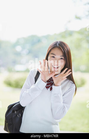 Carino il giapponese studente di scuola superiore in un parco della città Foto Stock