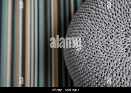 Grigio gigante cuscino in maglia di lana a strisce sulla moquette in camera da letto. Interior design scandinavo Foto Stock