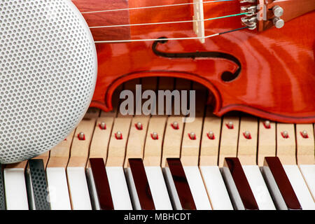 Altoparlante moderno e violino classico in bianco e nero di tasti di pianoforte close-up sullo sfondo Foto Stock