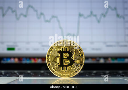 Bitcoin su un computer portatile con la tendenza dei prezzi graffic sullo sfondo Foto Stock