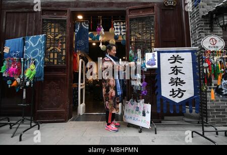 (180411) -- CHANGCHUN, Aprile 11, 2018 (Xinhua) -- Li Andi organizza le merci presso il suo negozio di Changchun, a nord-est della Cina di provincia di Jilin, Aprile 11, 2018. Li ha studiato arte popolare e artigianato design e graduata da Jilin Università agricola nel 2006. Dal 2015, ha iniziato a ricerca cultura sciamano e progettato prodotti correlati al suo studio. Ha aperto un negozio maker in Changchun nel marzo 2018 e vuole proteggere la tradizionale cultura sciamano attraverso il suo design di prodotto. (Xinhua/Wang Haofei)(mcg) Foto Stock