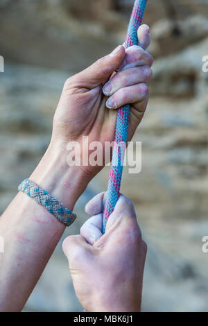 Mani tenendo una corda di nylon arrampicata Foto Stock