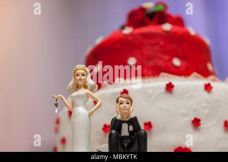 Figurine sul fondo del rosso e del bianco torta di nozze Foto Stock