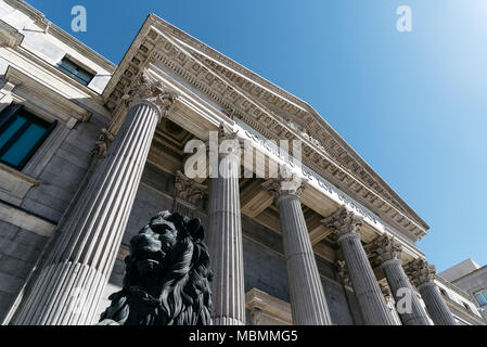 Basso angolo vista di ingresso principale al parlamento spagnolo con statue in bronzo di leoni Foto Stock