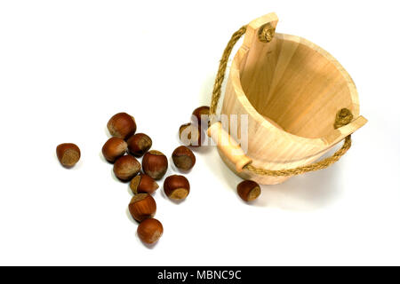 Nocciole e vuoto busket di legno su sfondo bianco Foto Stock