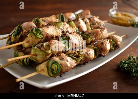 Grigliata di spiedini di pollo. Estate barbecue picnic food. Carne alla griglia su sfondo di legno con spezie Foto Stock