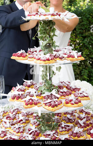 Primo piano di una torta nuziale fatta di piccolo cuore forma torta al lampone Foto Stock