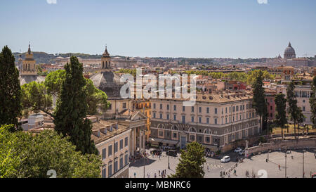 Vista dello Skyline di guardando sui tetti e le cupole della chiesa sopra Piazza del Popolo a Roma, Italia. La basilica di san Pietro nella Città del Vaticano può essere visto nel lontano dist Foto Stock