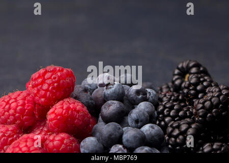 Frutti di bosco, lamponi mirtilli e more, su ardesia tagliere Foto Stock