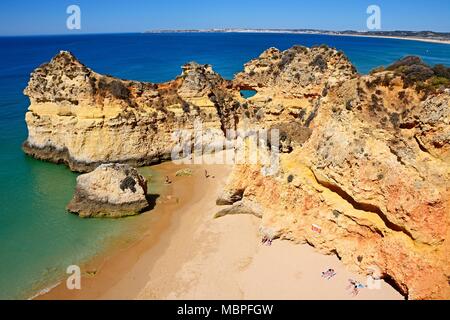 Vista in elevazione della costa rocciosa con turisti rilassati sulla spiaggia Praia da Rocha, Algarve, Portogallo, dell'Europa. Foto Stock