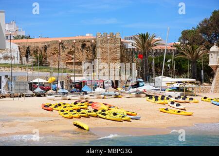 Vista del Palazzo dei governatori con Canoe sulla spiaggia in primo piano e una torretta sulla Ponta da Bandeira Fort al lato destro, Lagos, Alga Foto Stock