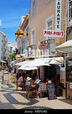 I turisti in un momento di relax a caffetterie lungo R Lima Leitao nella città vecchia, Lagos, Algarve, Portogallo, dell'Europa. Foto Stock