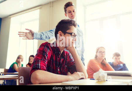 Classmate offendere studente ragazzo a scuola Foto Stock