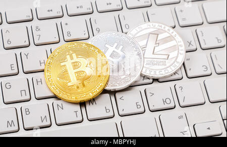 Monete di cryptocurrency giacente sulla tastiera del computer. Il concetto di business di nuovo denaro virtuale Foto Stock